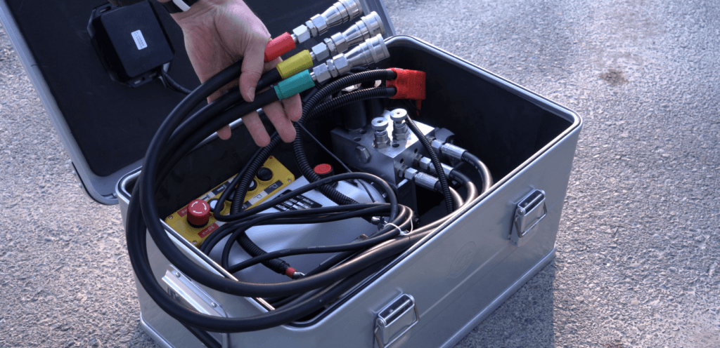 Portable hydraulic pump with color coded hoses.