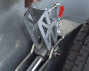 A photograph of the cylinder lock being raised towards the toggle clamp.