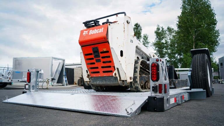 Construction site solutions. Back view of Bobcat on 13' flatbed flat on ground