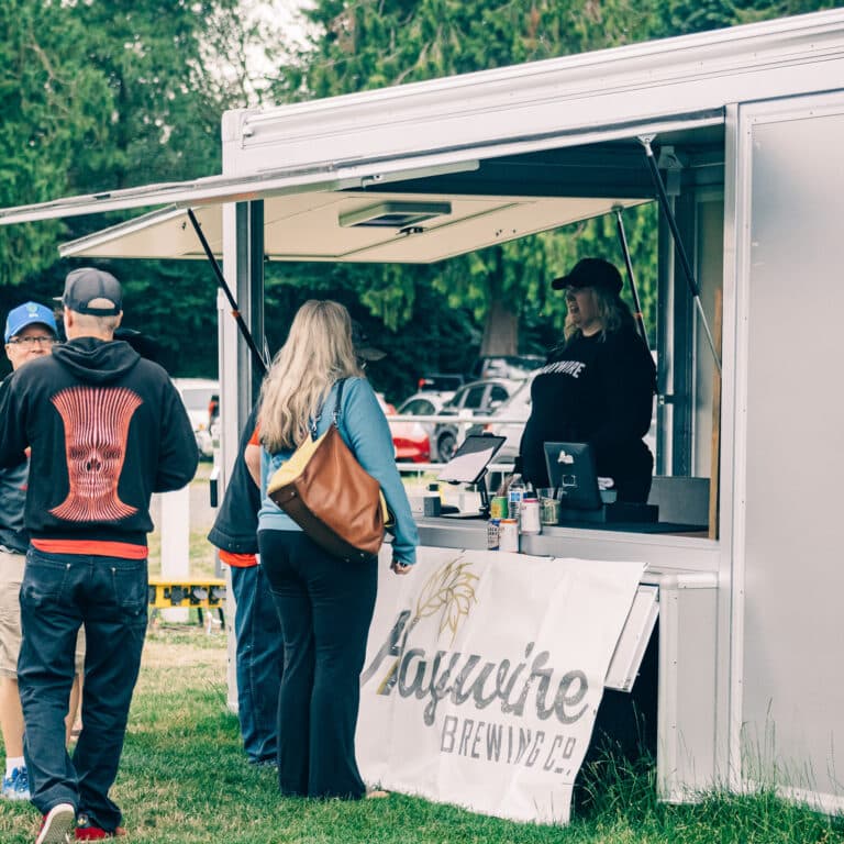 Close up of people buying beer at the Haywire brewing trailer.