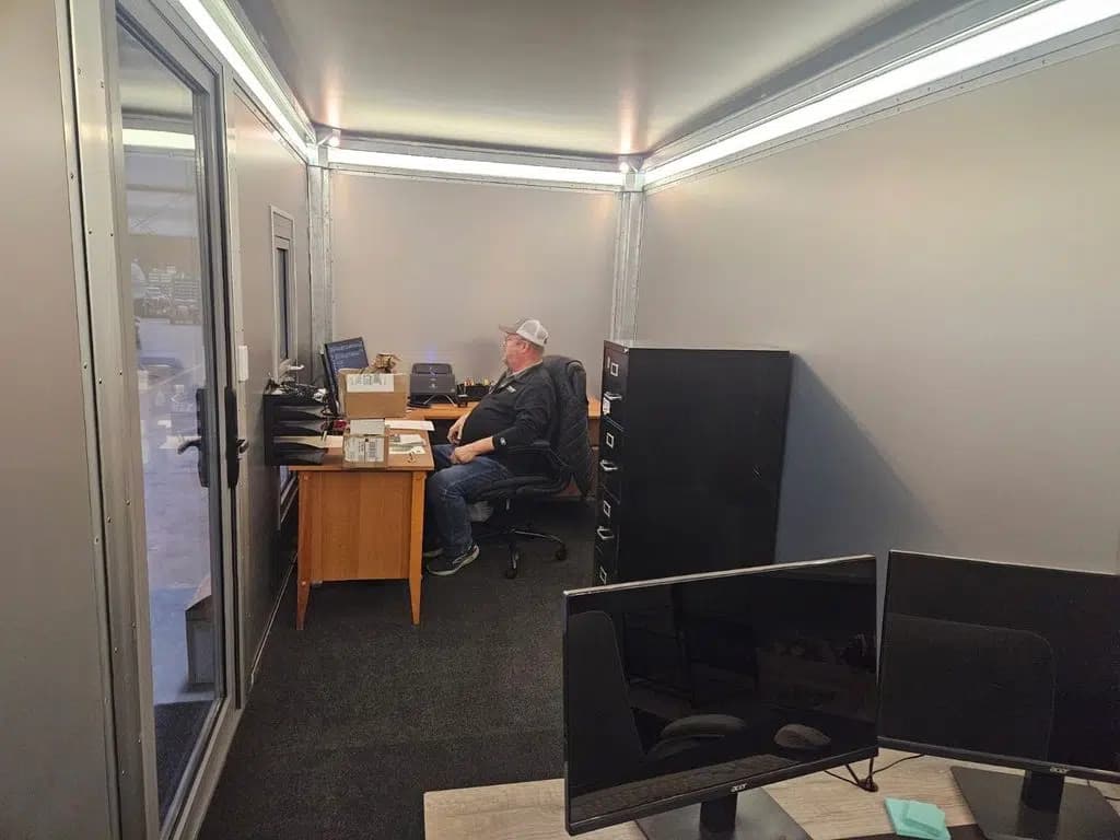 Rapid Deployment Modular Structure - Modular Office Building - Interior, two workstations, one man at work. 