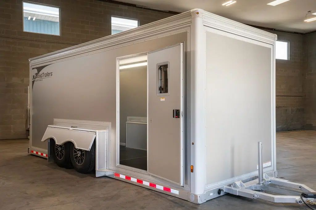 Drop deck trailers vs. tilt trailers - enclosed drop deck trailer on the ground.