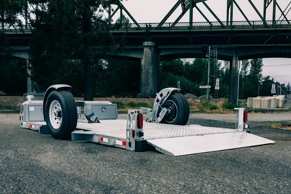 Compact Sweeper Trailer - 13' drop deck trailer sitting at a public park with the ramp down.