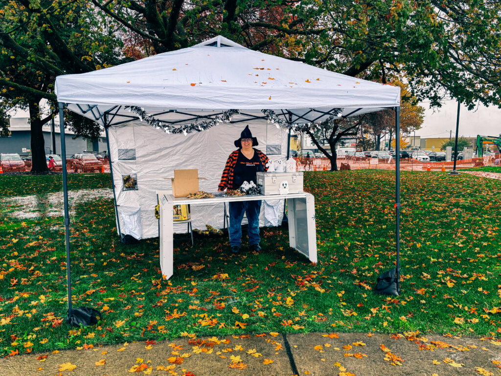 GoodMFG employee dressed as a witch at a Halloween booth